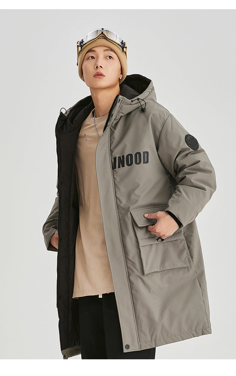 A man in olive NEIGHBORHOOD parka partially unzipped shows beige shirt underneath with beanie and plaid scarf against white background