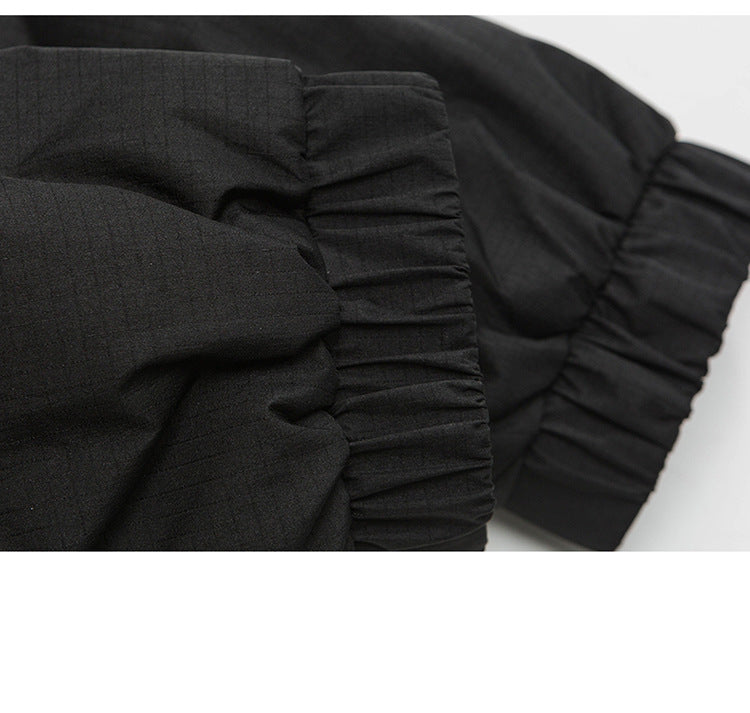 Close-up of black jacket showing elastic cuff detail and fabric texture