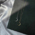 Silver and gold crescent moon necklaces displayed against dark slate background