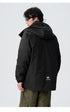 Back view of black technical jacket with Deserve branding and utility details against white background