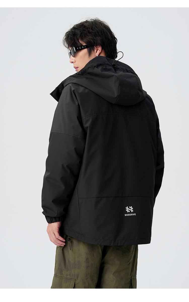 Back view of black technical jacket with Deserve branding and utility details against white background