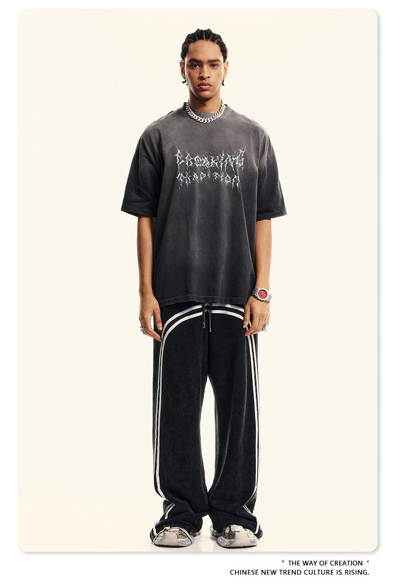 Model in gray Breaking Tradition tee and track pants, showcasing urban streetwear styling