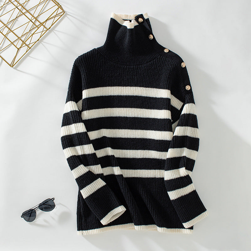 A black and cream striped turtleneck sweater with gold button shoulder detail, displayed flat against white background with stylish accessories