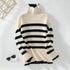 A cream and black striped turtleneck sweater with gold button shoulder detail, displayed flat-lay style with sunglasses as styling accent