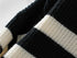 Close-up detail of black and cream striped knit fabric showing the ribbed texture and contrast between the two colors