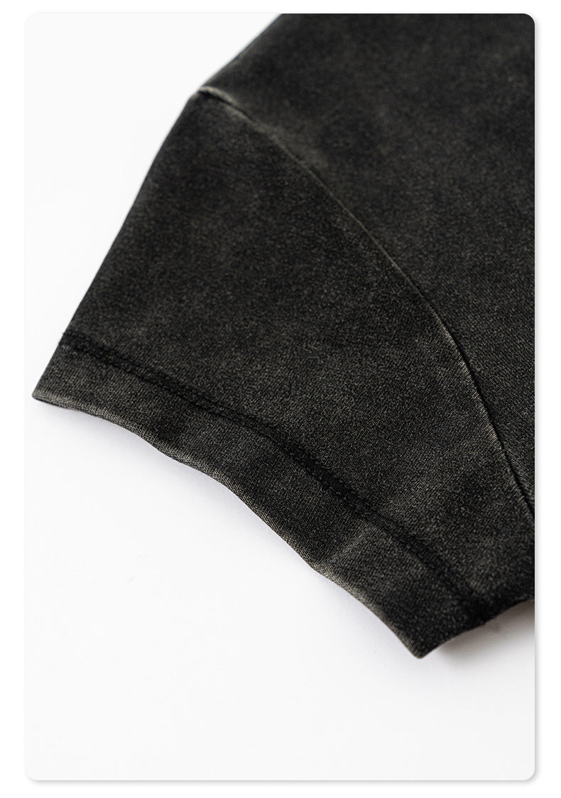 Zoomed-in shot of the neatly stitched hem on the sleeve of the black washed cropped T-shirt
