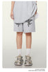 Gray melange sweatshorts with cupid graphics and elasticated drawstring waist, shown with white crew socks and chunky sneakers
