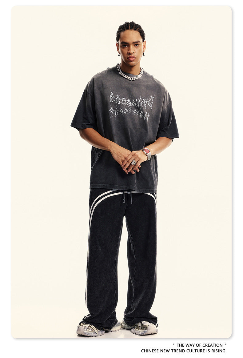Front view of gray oversized tee with gothic text design, styled with silver accessories
