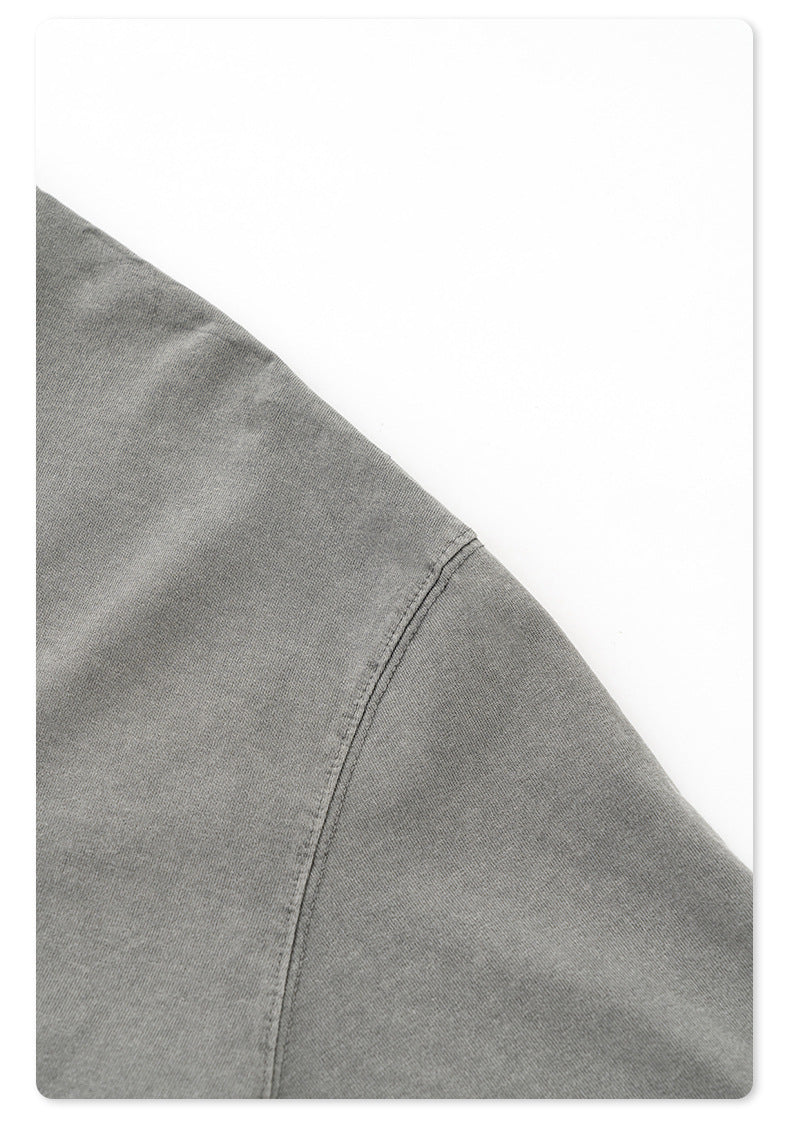 Detail of sleeve hem construction showing quality stitching on gray cotton t-shirt