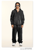 Black oversized zip hoodie with matching wide-leg pants, model has twisted hair, square sunglasses, layered chains
