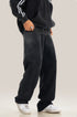 Side profile of black relaxed sweatpants with classic white sneakers