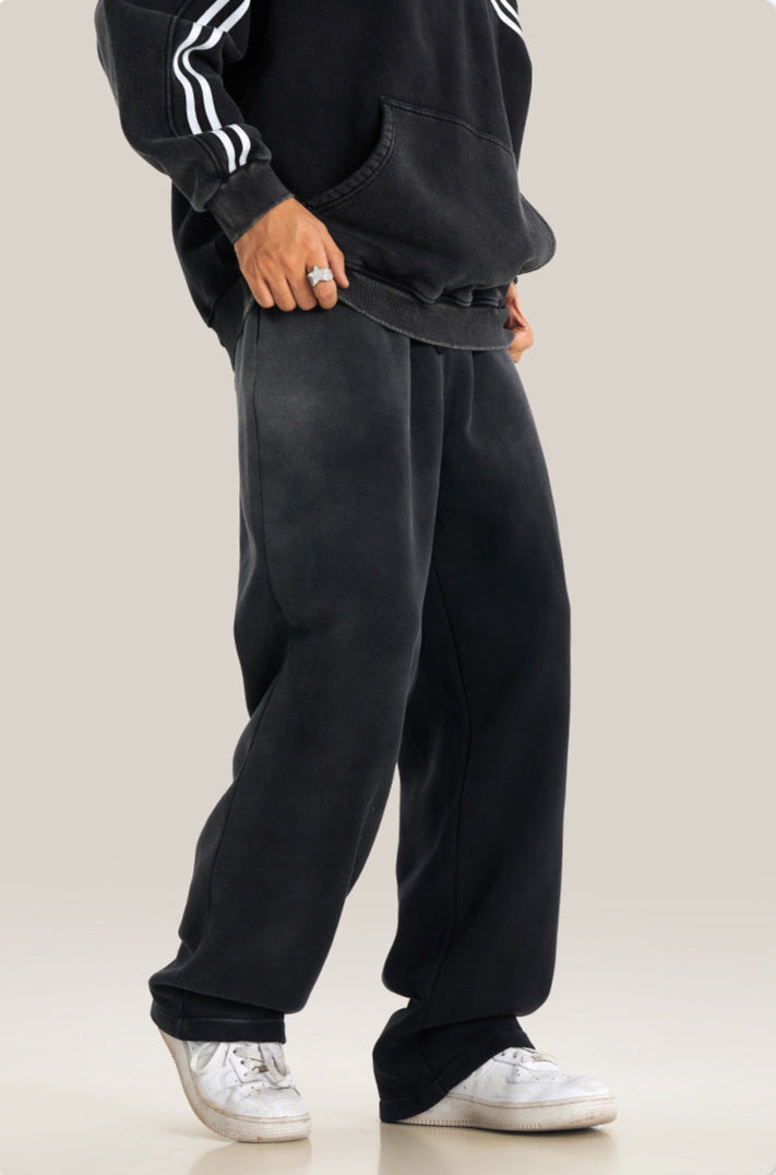 Side profile of black relaxed sweatpants with classic white sneakers