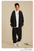 Woman in black oversized zip-up hoodie and sweatpants worn with white t-shirt and silver chain necklace.gif