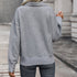 Back view of gray textured pullover showing basket weave pattern, decorative buttons at cuff, paired with dark jeans