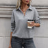 Woman holding coffee cup wearing gray textured collared pullover with gold necklace against concrete wall background