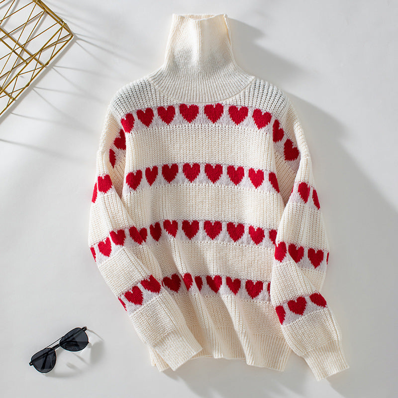 White chunky knit turtleneck sweater with horizontal red heart pattern rows displayed on white background with decorative gold element