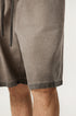 A close-up of taupe washed cotton shorts showing drawstring detail and fabric texture against light background