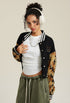 Side view of black cropped varsity jacket with tan camouflage sleeves and white stripe trim