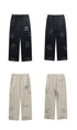 Product lineup showing black and cream Backstairs sweatpants, front and back views with distressed paint-splatter patterns