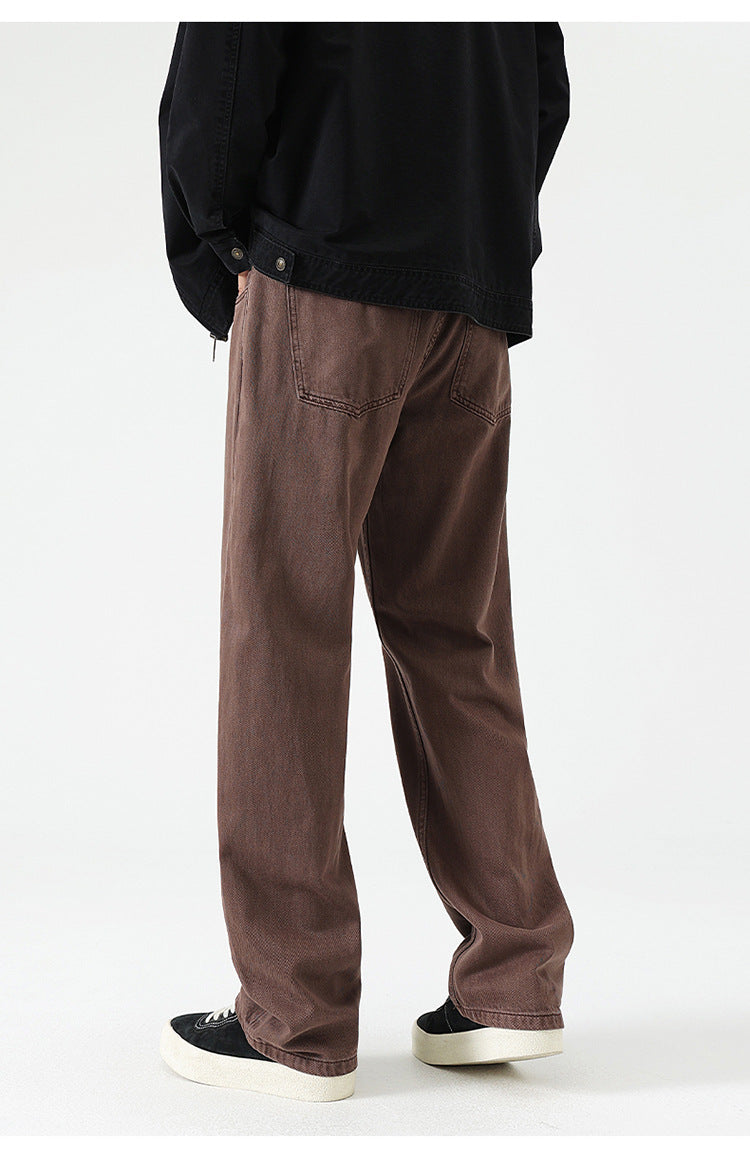 Close-up of brown wide-leg jeans pocket detail, showing stitching and button closure