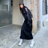Side view of black maxi cargo skirt showing drawstring hem detail, paired with sporty streetwear accessories