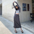 Grey cargo maxi skirt with utility pockets, styled with cropped top and chunky sandals outside boutique storefront