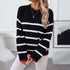 Casual winter fashion look with black ribbed sweater, white horizontal stripes, red cuffs, and decorative gold lock pendant necklace