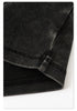 Close-up of the folded sleeve hem on a black washed cropped T-shirt, showing precise stitching and fabric texture