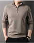 Taupe quarter-zip pullover sweater with standing collar and raglan sleeves, worn with black pants and wristwatch
