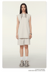 Model wearing cream/beige matching set with sleeveless top and shorts, white socks and chunky sneakers on neutral background