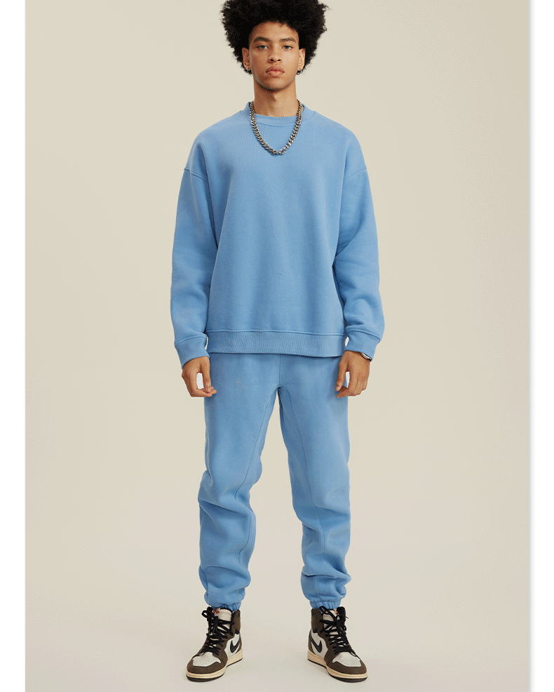 Model in light blue sweatsuit with crew neck top, matching joggers and Nike high-tops