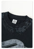 Close-up of black Backstairs t-shirt neckline and tag showing distressed fabric texture against white background