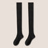 Pair of black knee-high socks with visible texture sections displayed against cream background
