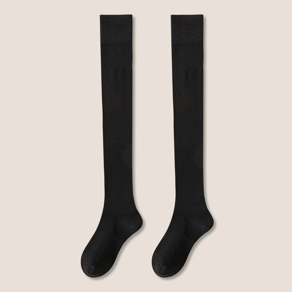 Pair of black knee-high socks with visible texture sections displayed against cream background