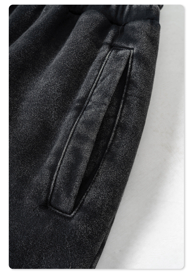 Detail shot of pocket construction on black denim jogger pants with minimalist design against white background