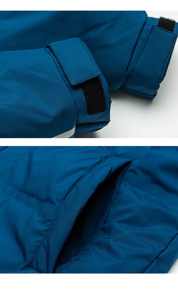Close-up detail of blue puffer coat showing adjustable sleeve cuff with velcro closure and white stripe detail against white background