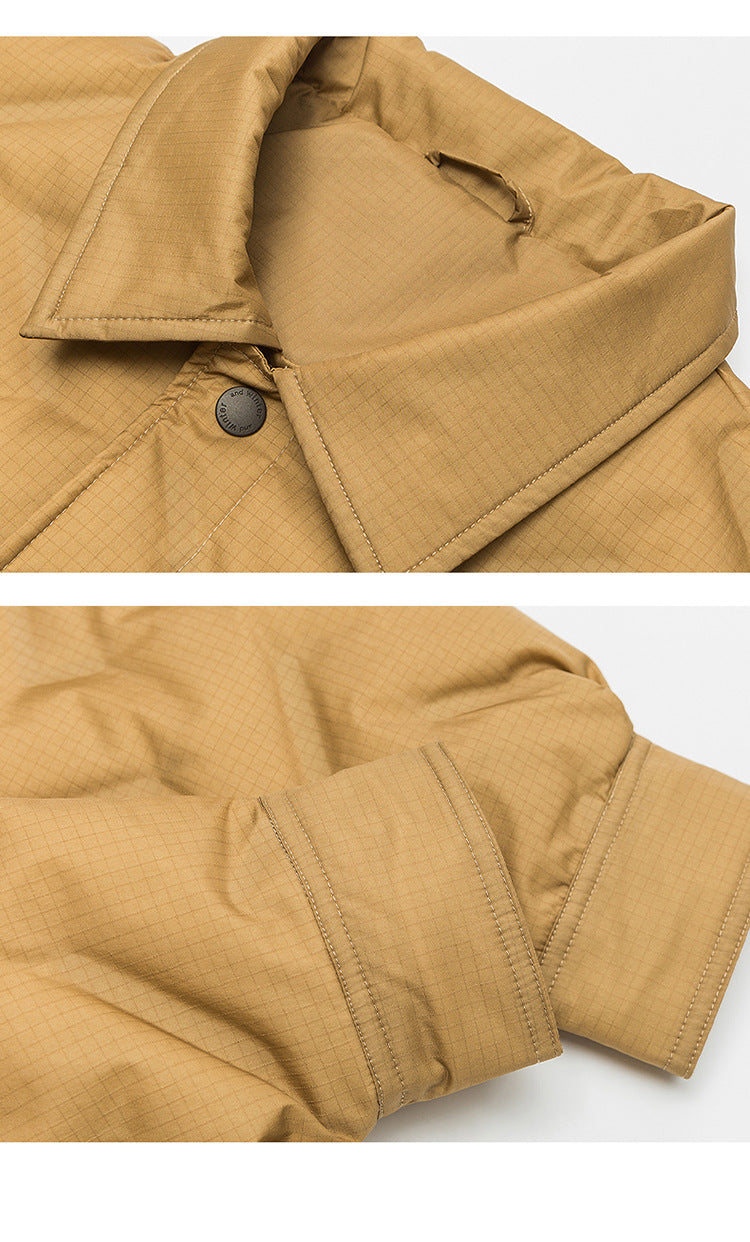 Close-up detail of tan quilted jacket collar with metal snap button and textured ripstop fabric