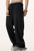 Side view of black sweatpants highlighting the relaxed fit, elastic waistband, and drawstring closure.