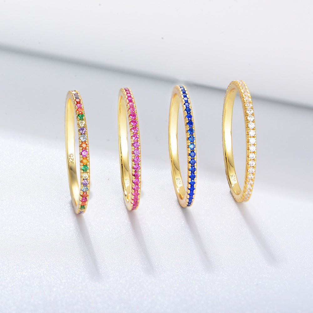 Collection of 14k gold stackable rings featuring multicolor, pink, blue and light blue zircon eternity bands