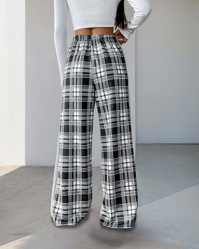 Back view of black and white plaid wide-leg pants featuring an elastic waistband, styled with a white long-sleeve top.