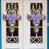 Two purple floral cross wreaths with bows on white double doors, featuring tulips, greenery, and a cascading floral design.