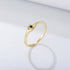 Gold ring with small blue sapphire in eye-shaped setting against white background