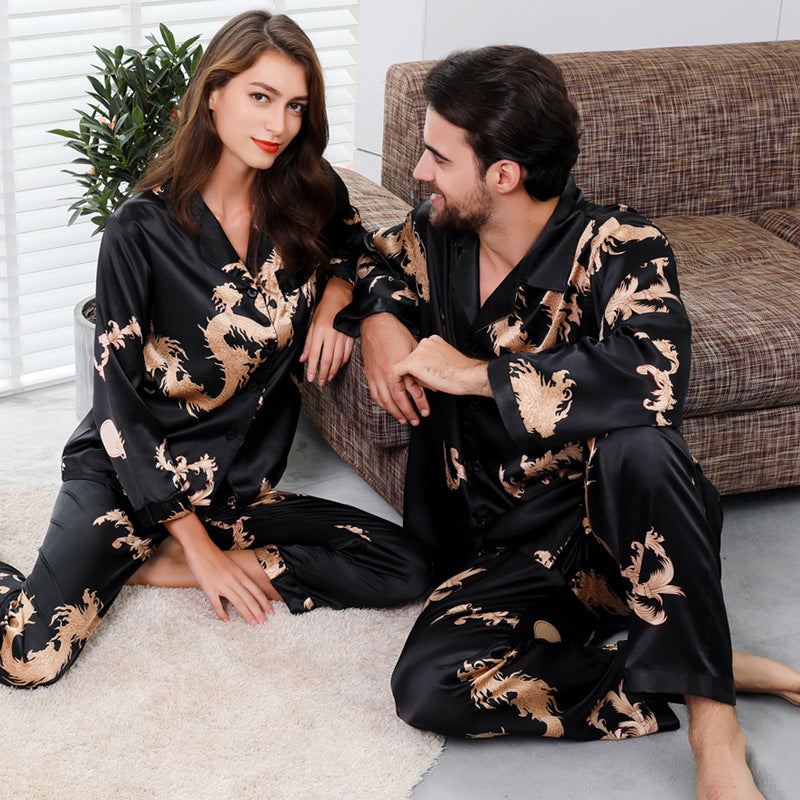 Matching black couple's silk pajamas with golden dragon print, featuring long-sleeve top and pants for coordinated loungewear