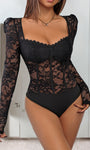 Woman wearing a black lace long-sleeve bodysuit with scalloped neckline and underwire cups.