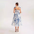 Back view of white and blue floral organza dress, showcasing detailed bow straps and fitted silhouette