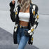 Model wearing black daisy-print cardigan with a white crop top and jeans