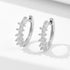 Sterling silver huggie hoop earrings with five graduated crystal stones on white background