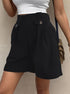 Elegant black tailored shorts with side buttons, white top, and gold accessories for minimalist fashion