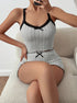 Ribbed knit pajama set in light grey with black lace trim, featuring a cropped camisole top and high-waisted shorts with bow details