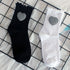 Ribbed crew socks in black and white with gingham heart patches, displayed on a grid surface